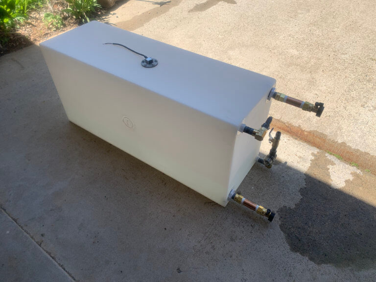 Water tank with plumbing connections and a tank sensor.