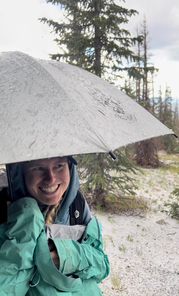 I stood with an umbrella during a thunderstorm at tree line waiting for the storm to stop before hiking onto an exposed ridge.