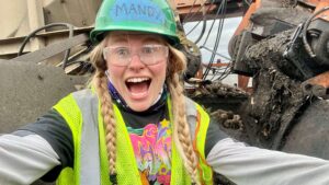 Selfie of woman cleaning a beet piler with the power locked off.
