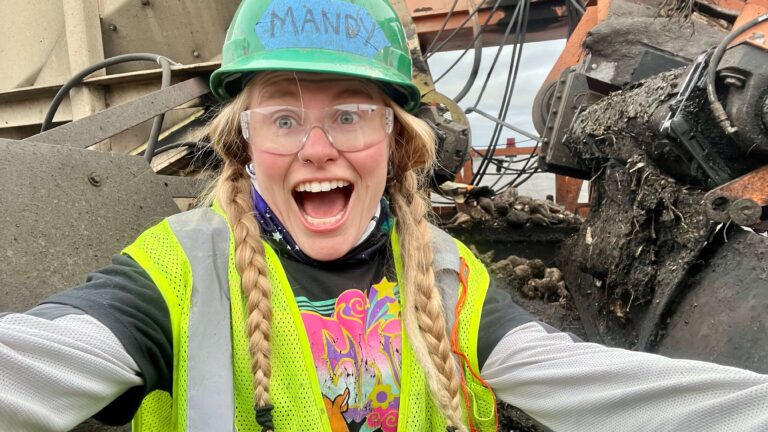 Selfie of woman cleaning a beet piler with the power locked off.