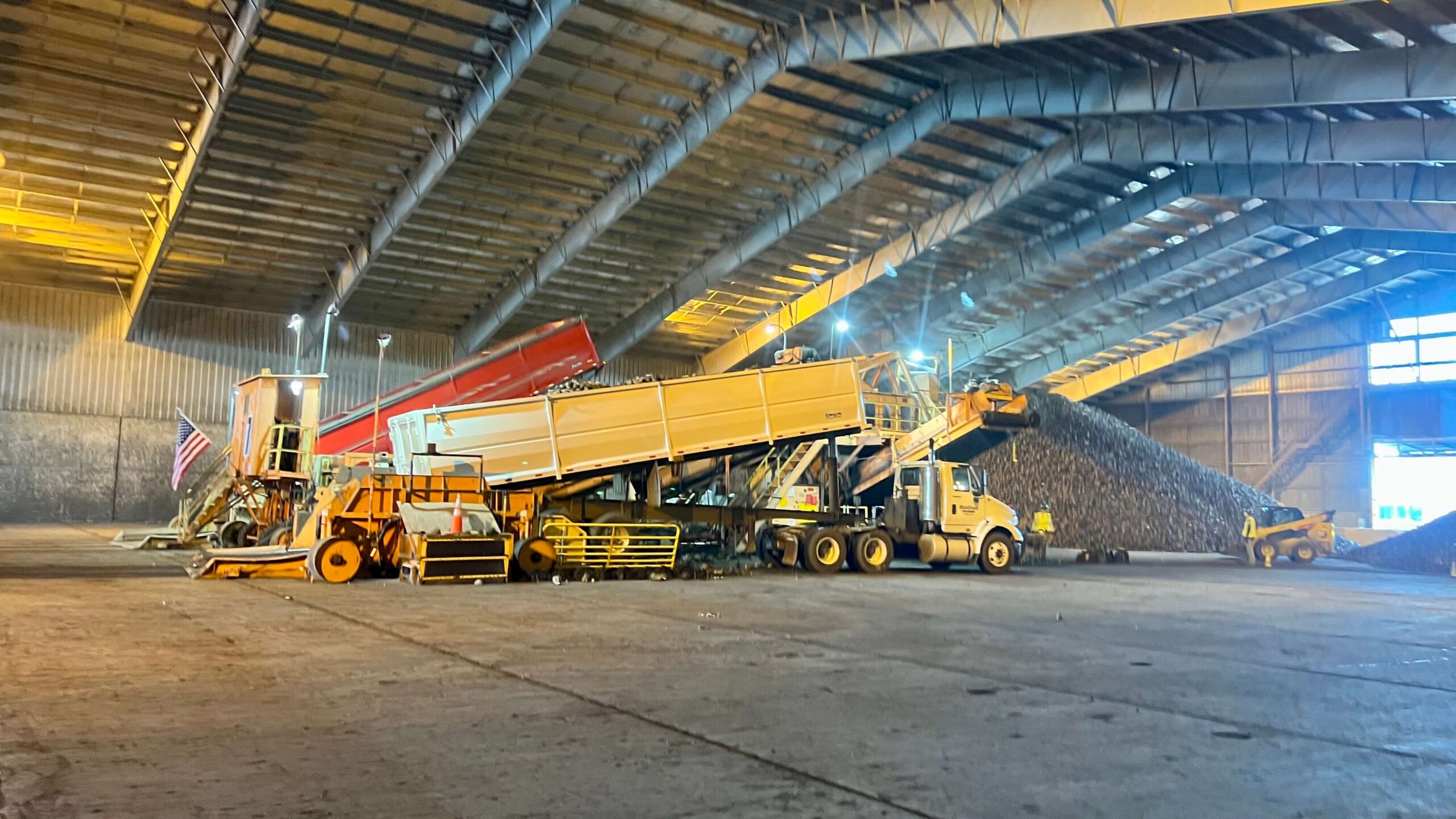 Two dump trucks unloading sugar beets into a piler to be stored for the winter