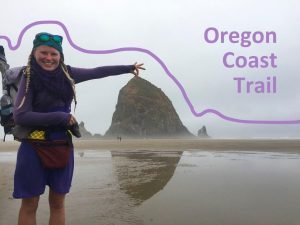 Woman thru-hiker on the Oregon Coast Trail pretending to hold a sea stack.