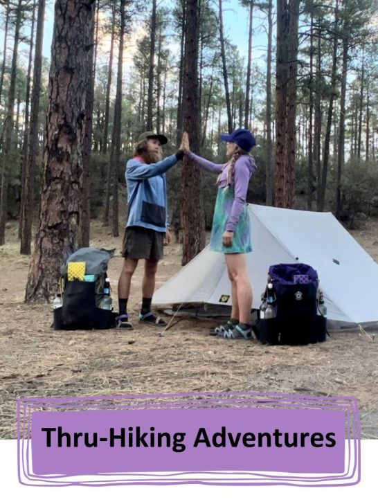 Two thru-hikers high-fiving after a long day hiking.