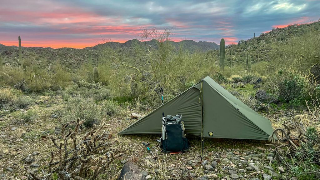Desert camping with tent and backpack.