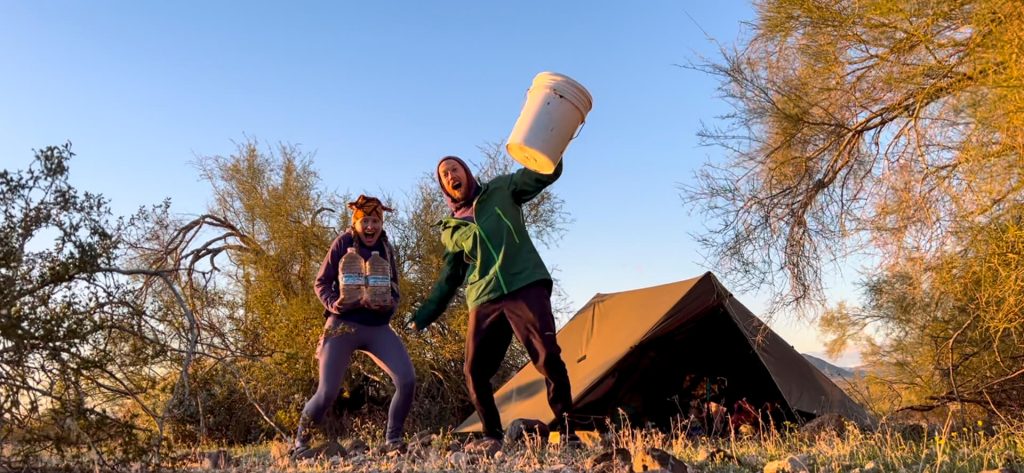 Two thru-hikers camping at their food and water cache.