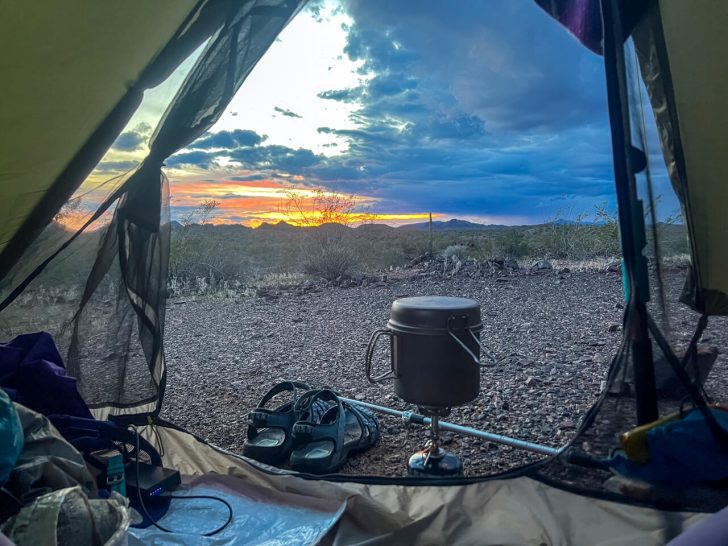 Cooking dinner next to the tent on trail in the desert.