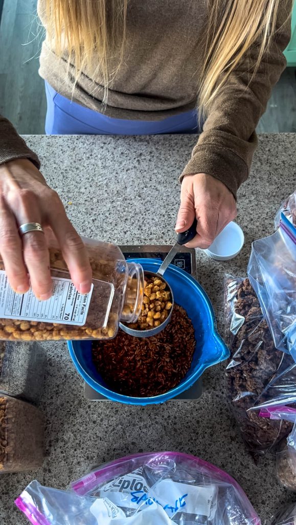 A bowl on a scale with a woman adding "chicken" (TVP) bits to it.