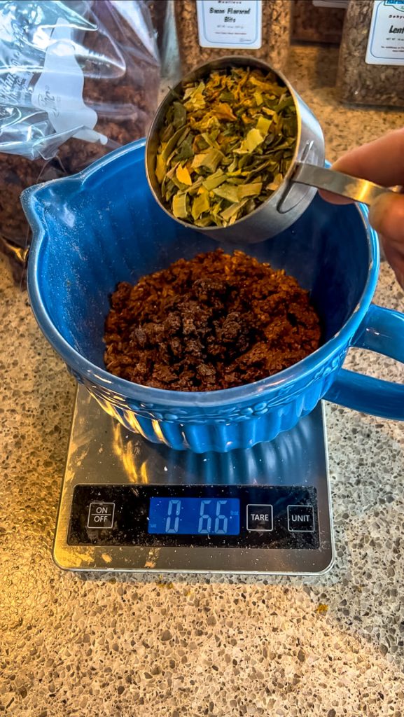 A bowl on a scale with dehydrated vegetables being poured in.