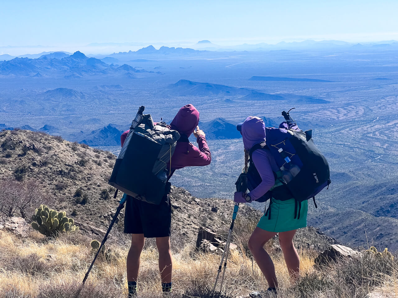 Two thru-hikers looking at the views from Harquahala Mountain in Arizona.