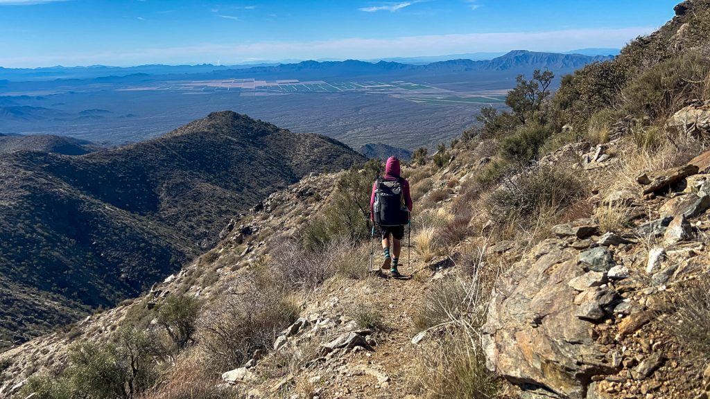 A thru-hiker descends Harquahala Mountain on trail.