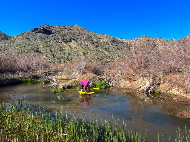 Thru-hiker finding a neoair sleeping pad hole in a river.