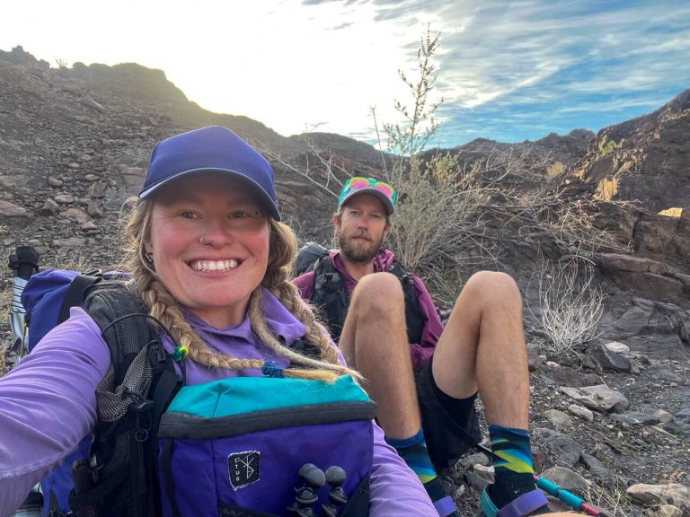 Two thru-hikers pause at a high point out of the wind for a selfie.