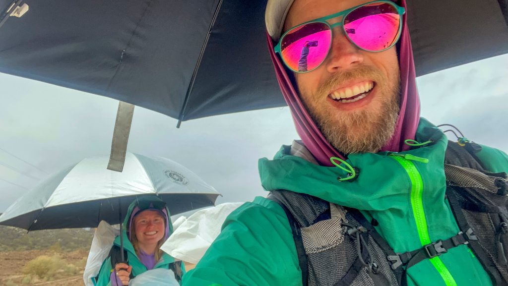 Thru-hiking couple hiking through the rain in their rain gear