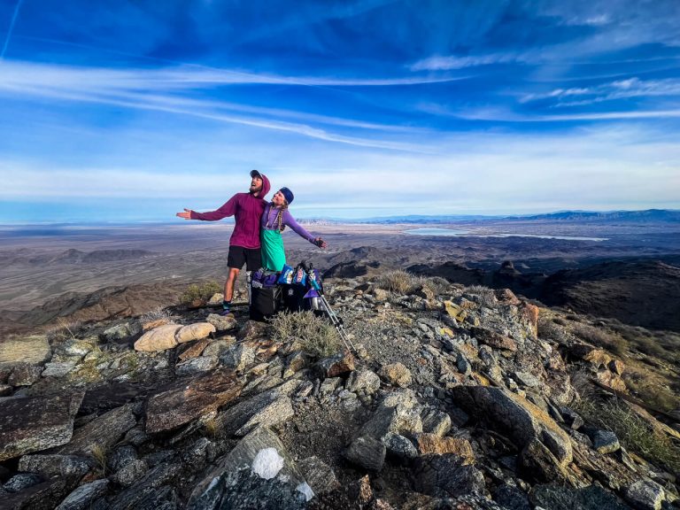 A hiking couple posing at the high point of the Whipple Range.