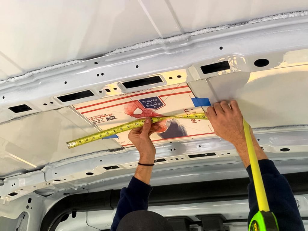 Using a cardboard template to place the fan's hole where we want inside the van.