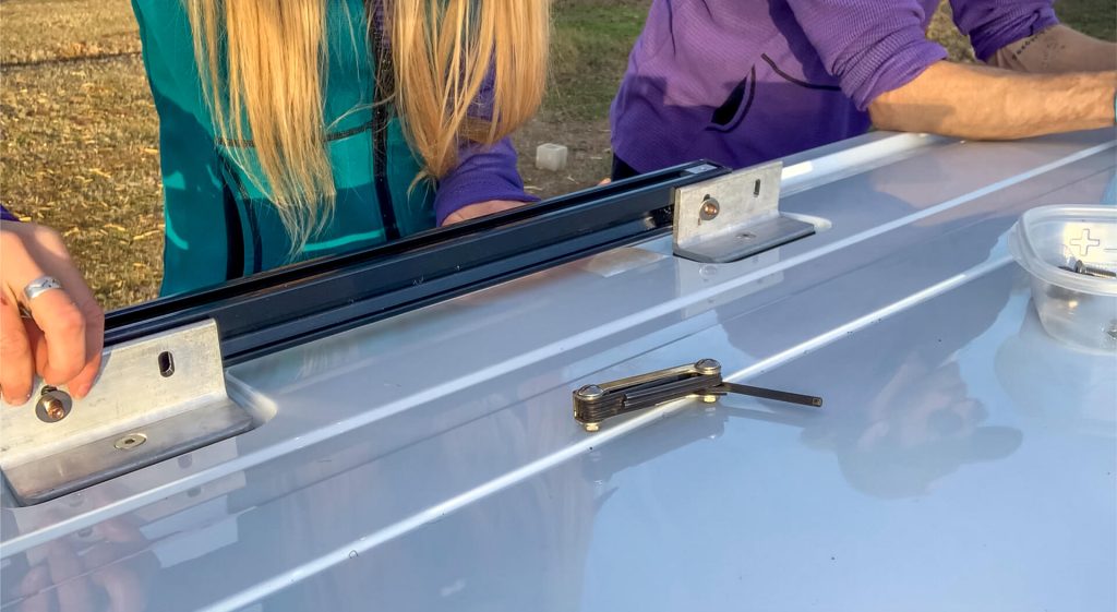 A van couple adding the bolts to the channels.