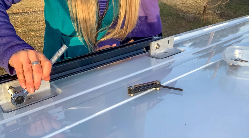 A woman ratcheting a bolt tight on a Prime Design Alurack .