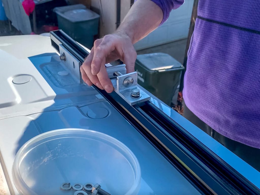 Adding the rack mounting brackets to the van roof rack channels.