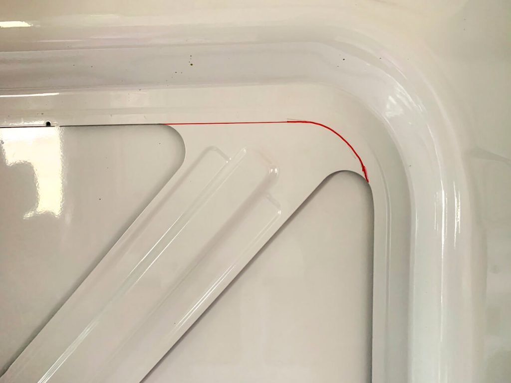 The ford transit factory imprint for a sliding door window added in aftermarket. The Sharpie line continues the factory imprint over the support metal.