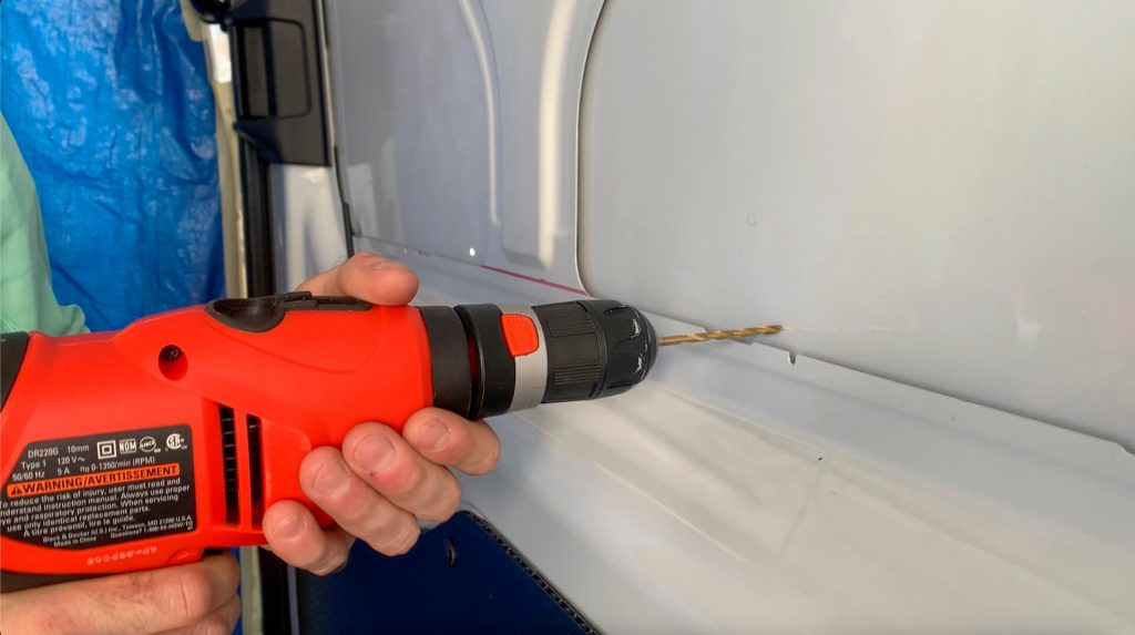 Getting ready to pre-drill holes for the jigsaw blade which will cut a hole for a van sliding window.
