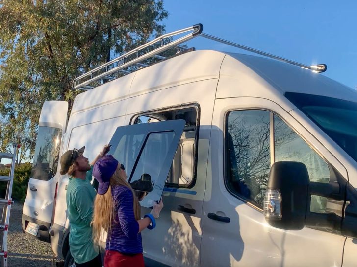 A van couple placing a sliding window onto their Ford Transit DIY van build.