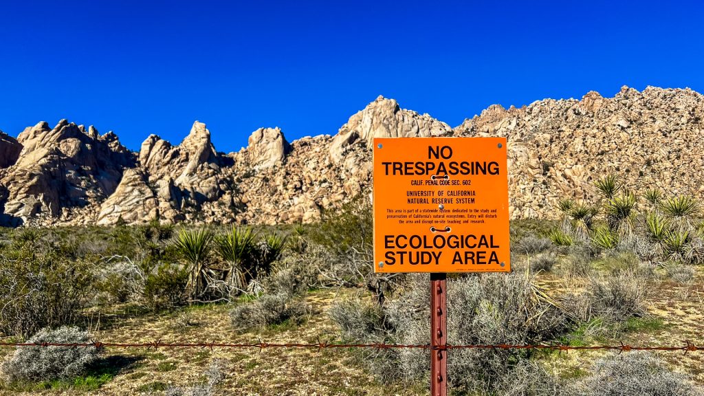 A sign designating an area of land for research studies in the Mojave Desert.
