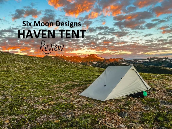 A haven tent pitched on a high alpine field with a bright sunset.