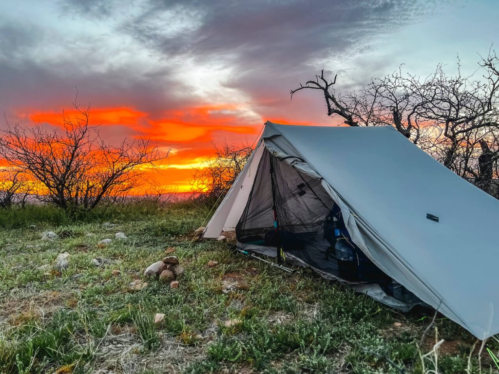 A tent pitched for sunset with the vestibule doors open.