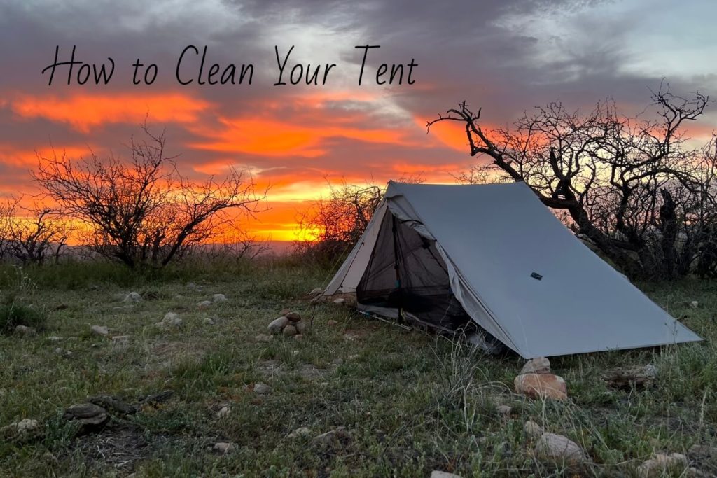 A tent set up in a desert sunset with text on how to clean a tent.