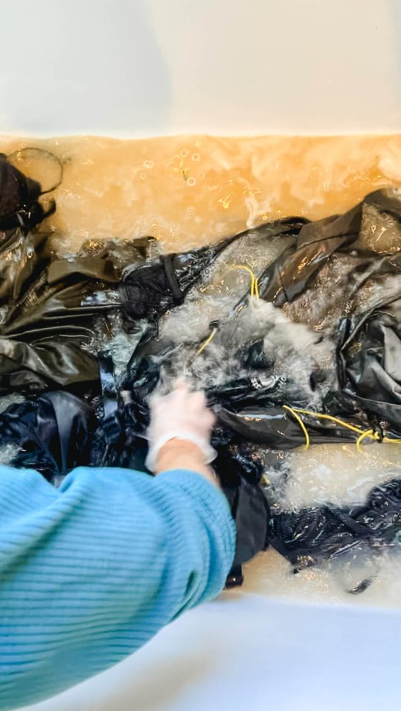 Agitating backpacks in a cleaning solution.