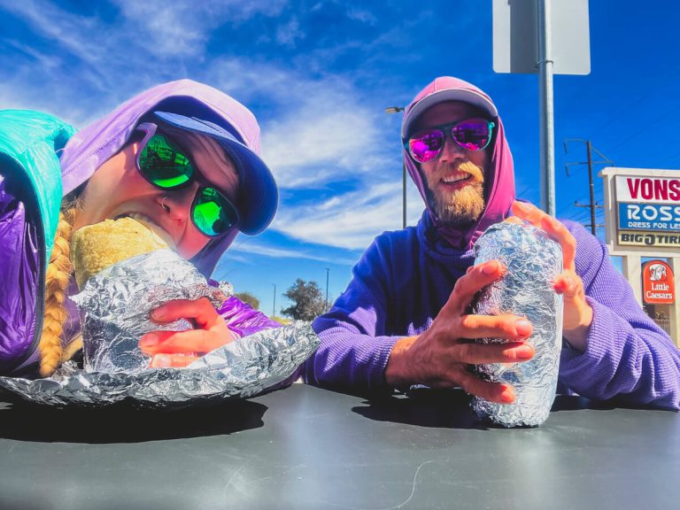 Two thru-hikers eating Chipotle burritos.
