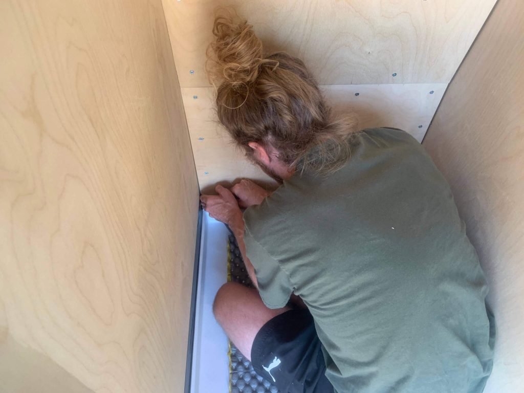 Adding Aqua Tape between the shower pan lip and the shower walls to create an inner waterproof seal.