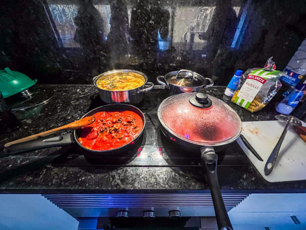 Cooking in an albergue kitchen: pasta, tomato sauce, beans, and veggies.