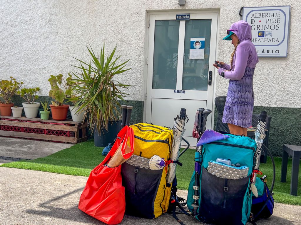 A hiker waiting outside an albergue for it to open.