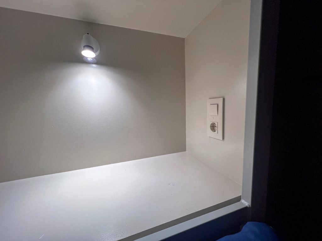 This light, electrical plug and shelf was at the head of each bunk.