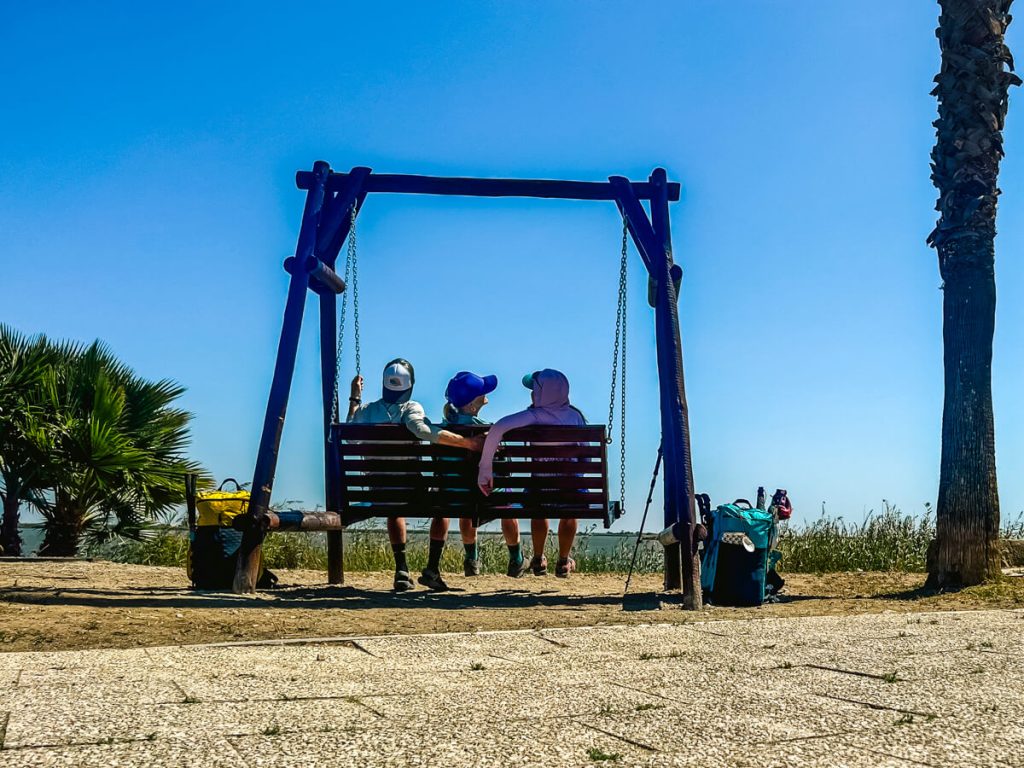 Three pilgrims on a swing on the Portuguese Camino between Lisbon and Porto.