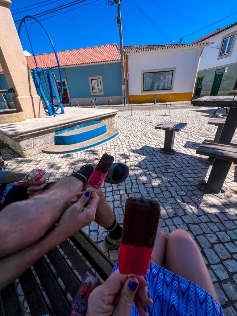 Eating our vegan popsicles in the shade near a cafe.