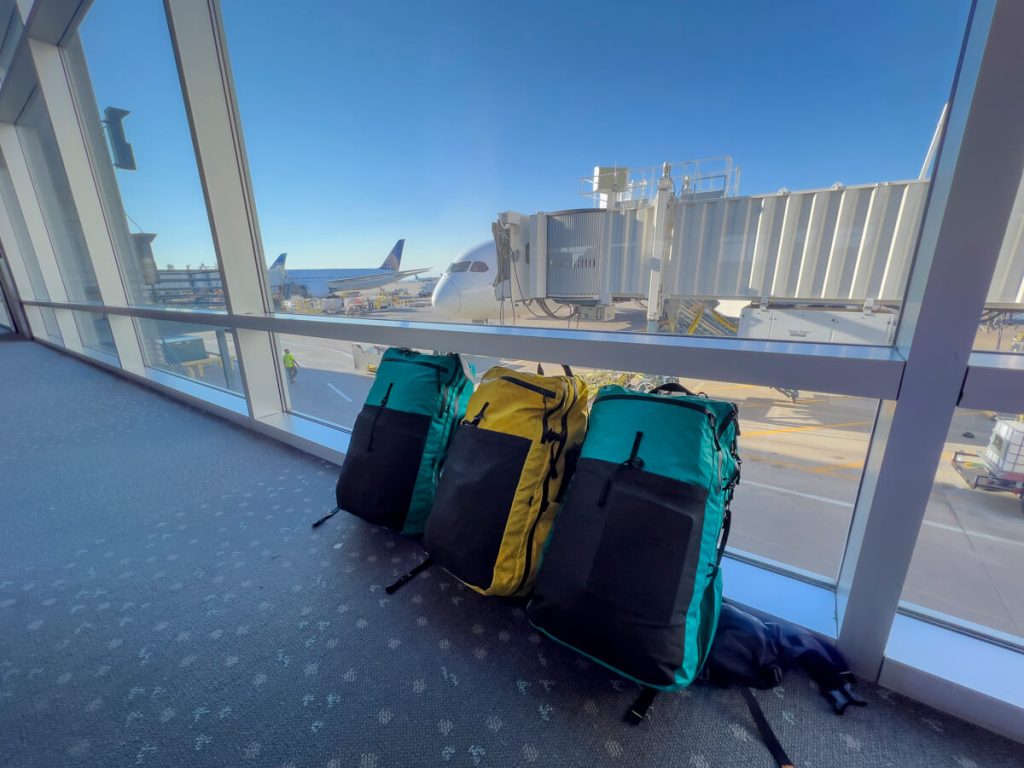 Three backpacks waiting to get on an airplane.
