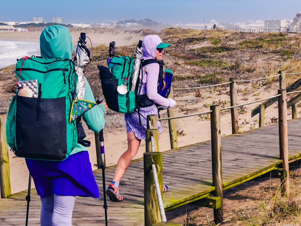 My Mom and I hiking on the Camino Portuguese Coastal Route on a boardwalk next to the beach.