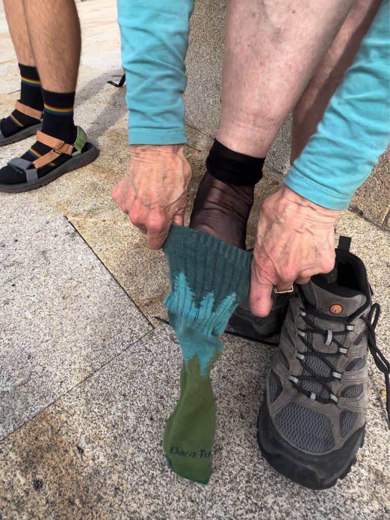My Mom using liner socks to prevent hiking blisters on the Camino de Santiago.