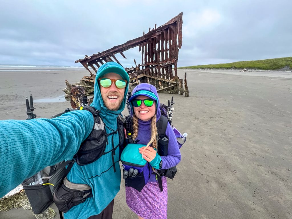 Veggie and Karma thru-hiking the Oregon Coast Trail by the shipwreck in Fort Stevens State Park.