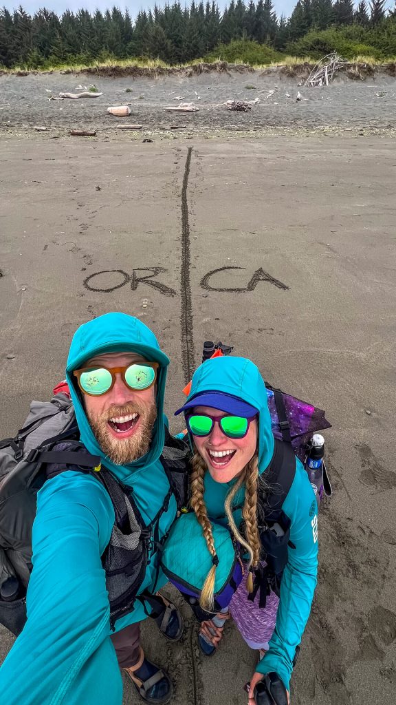 Veggie and Karma at the Oregon/California Border finishing the Oregon Coast Trail.