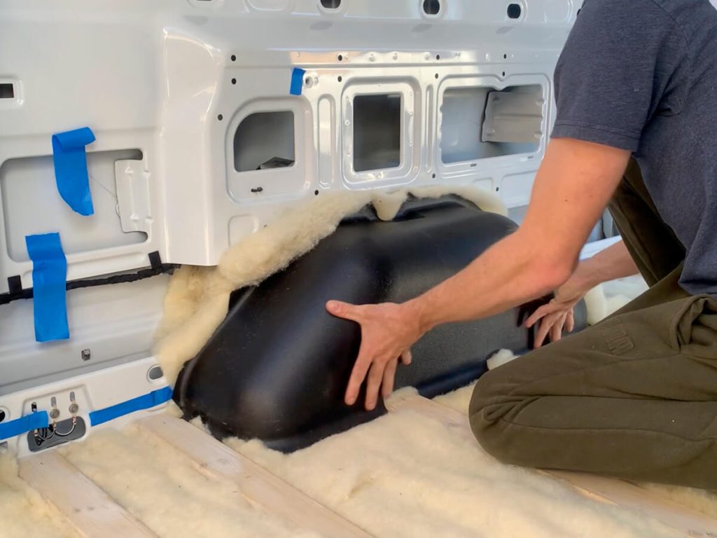 Sizing up the OEM wheel well cover with Havelock Wool insulation underneath.