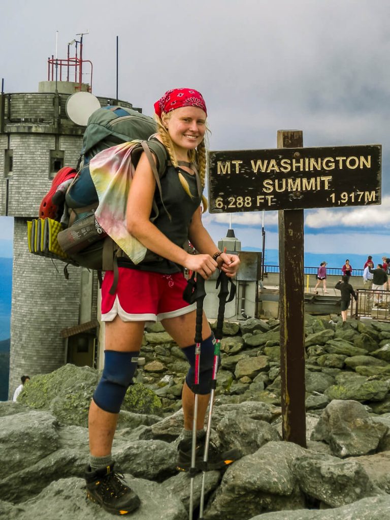 Woman thru-hiker on the Appalachian Trail on Mt. Washington wearing a Gregory Deva backpack.