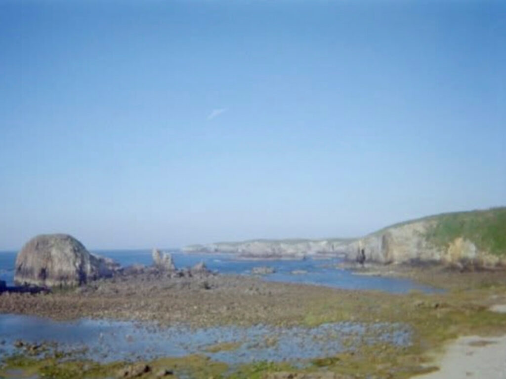 Walking next to tide flats on a sunny day on the Camino del Norte.
