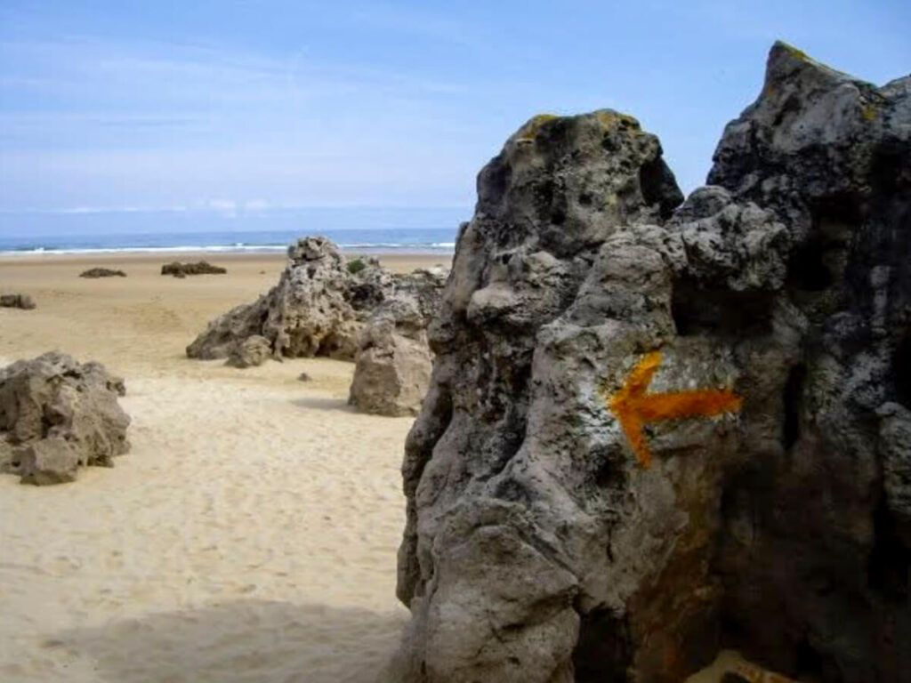 A yellow arrow on the beach in Spain.